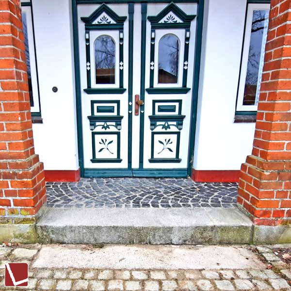 Treppenpodest mit Kleinpflaster vor historischem Guthaus